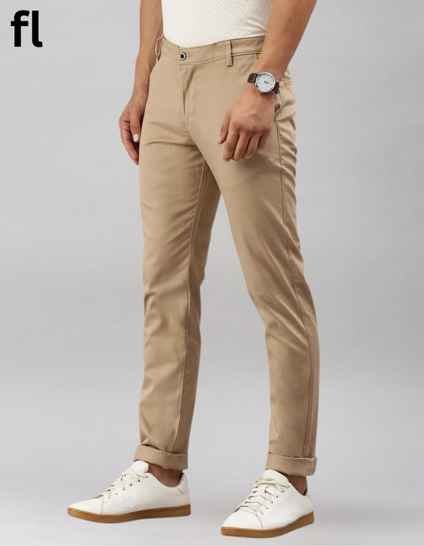 Person wearing beige pants and white sneakers on a gray background